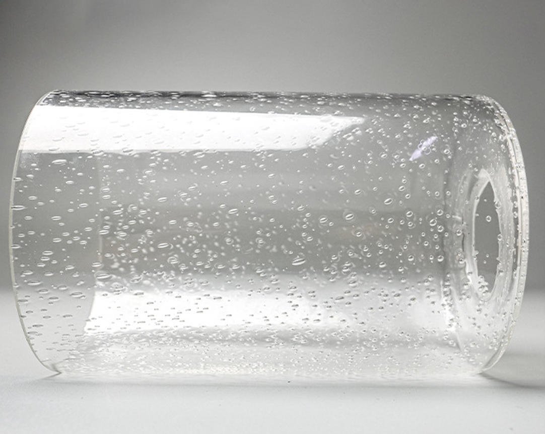 Clear seeded glass cylinder shade replacement with trapped air bubbles and standard mounting hole for pendant lights.