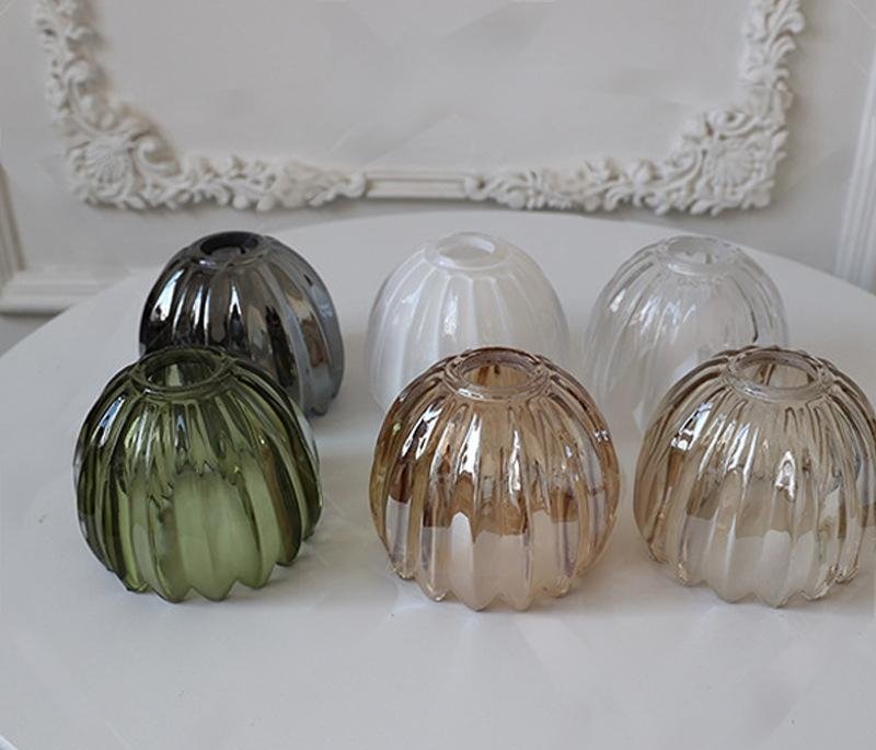 Collection of ribbed pumpkin glass lamp shades in amber, green, smoke grey, opal white, and clear. Fluted melon shape replacement globes for pendant lights and chandeliers.
