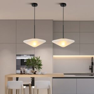 Modern white acid etched glass pendant lights hanging over a kitchen island, showing soft light diffusion.